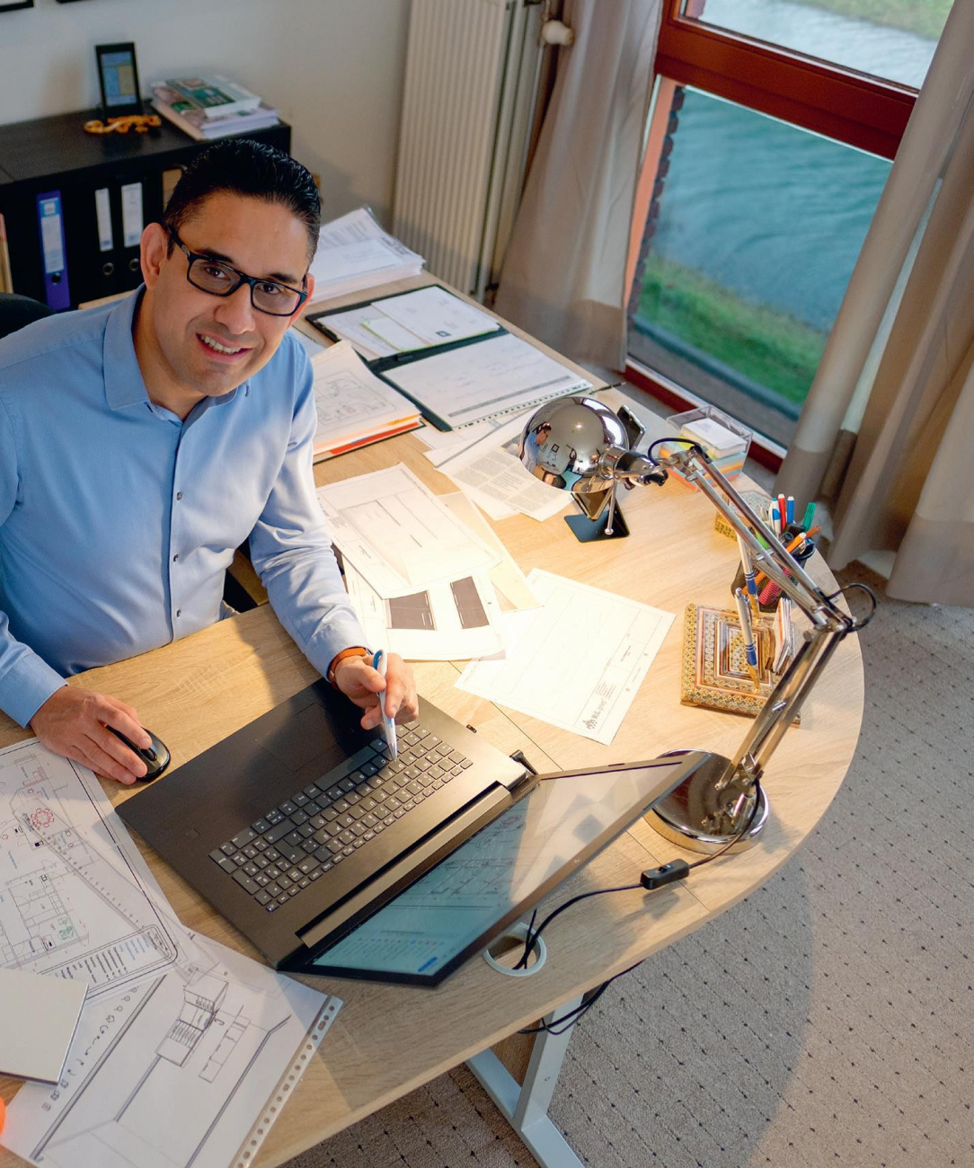 Tandarts Sepand Manouchehr achter zijn bureau na de verbouwing van zijn nieuwe praktijk